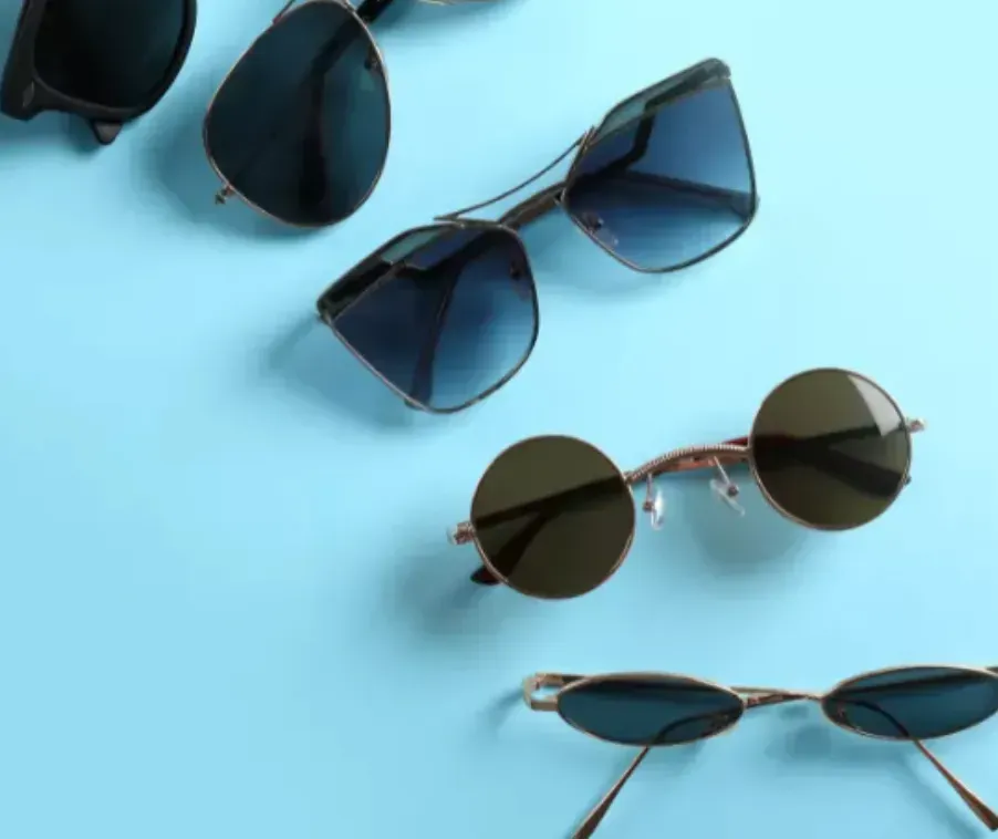 Assorted sunglasses arranged on a light blue background
