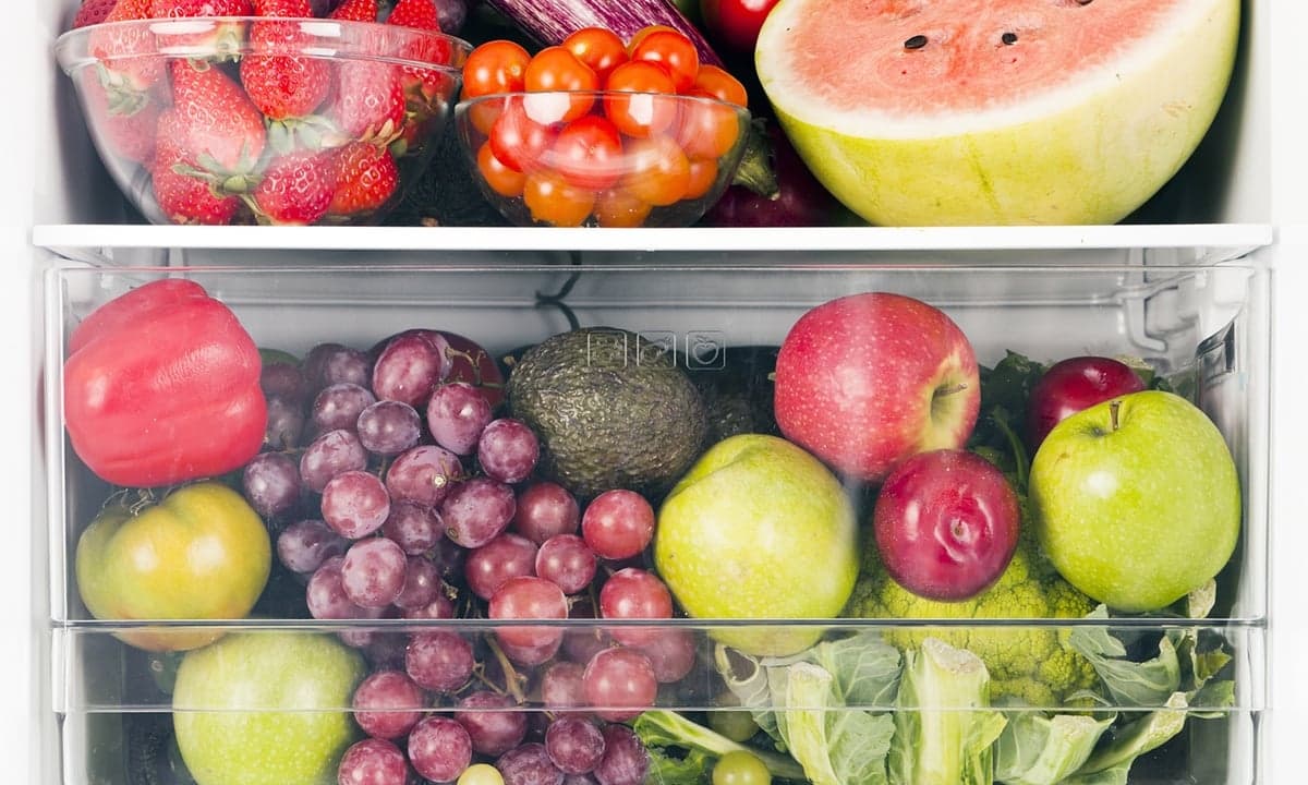 Refrigerator shelves stocked with fresh fruit and vegetables
