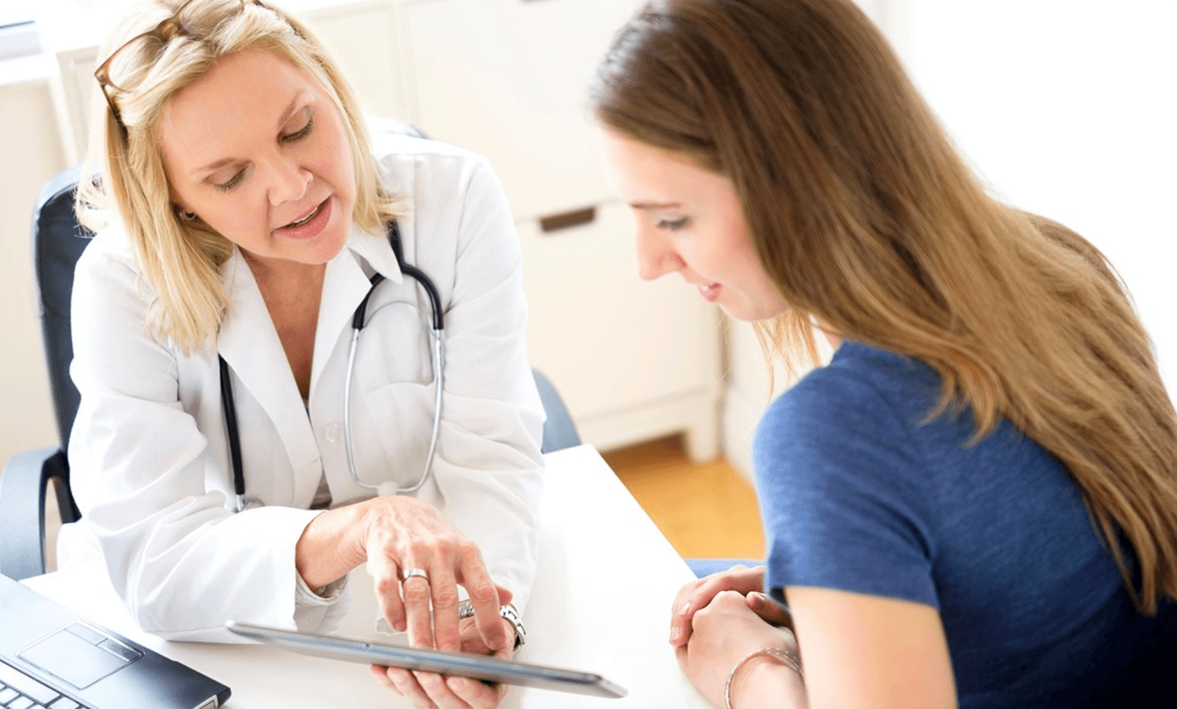 Doctor reviewing information on a tablet with a patient